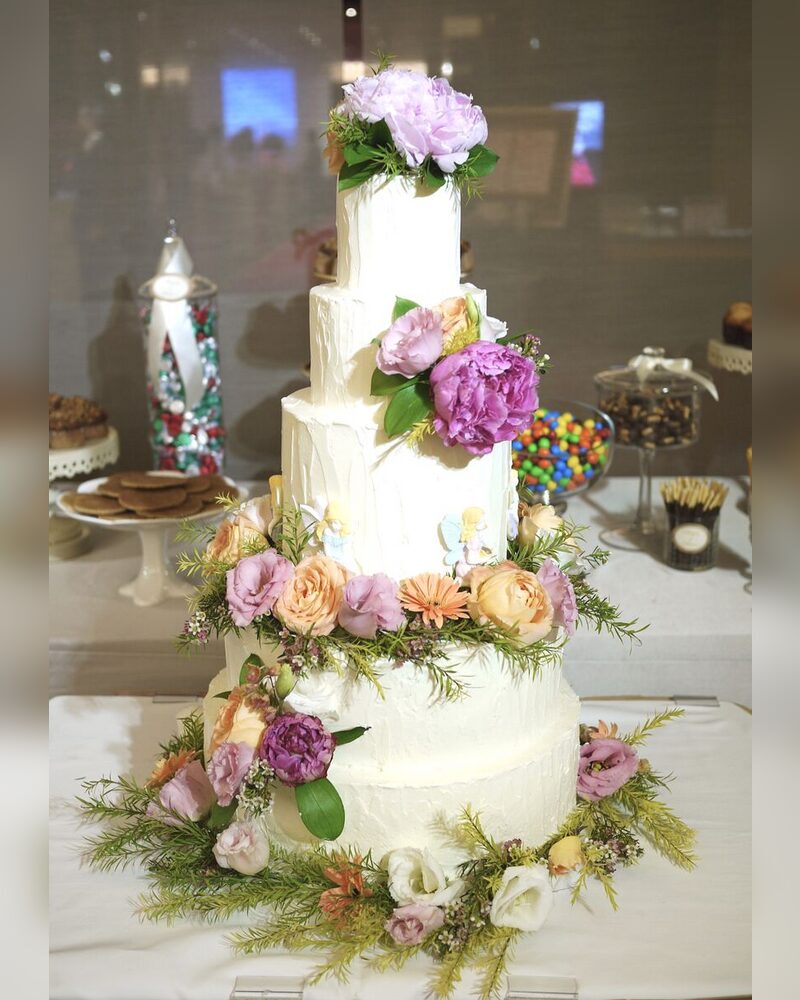 Rustic white tiers with fresh florals and greenery